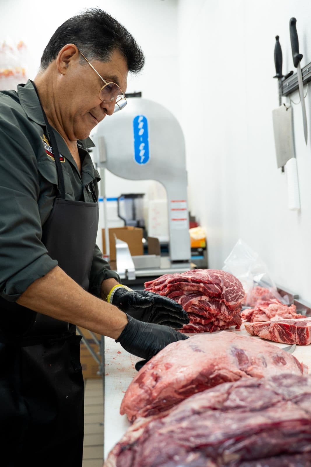A Caza Prime butcher hand-cutting steaks
